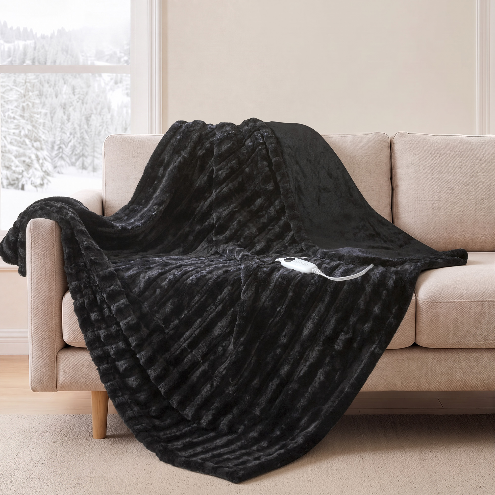 Black Beautyrest Heated Duke faux-fur throw draped on a sofa, with one white wired controller visible