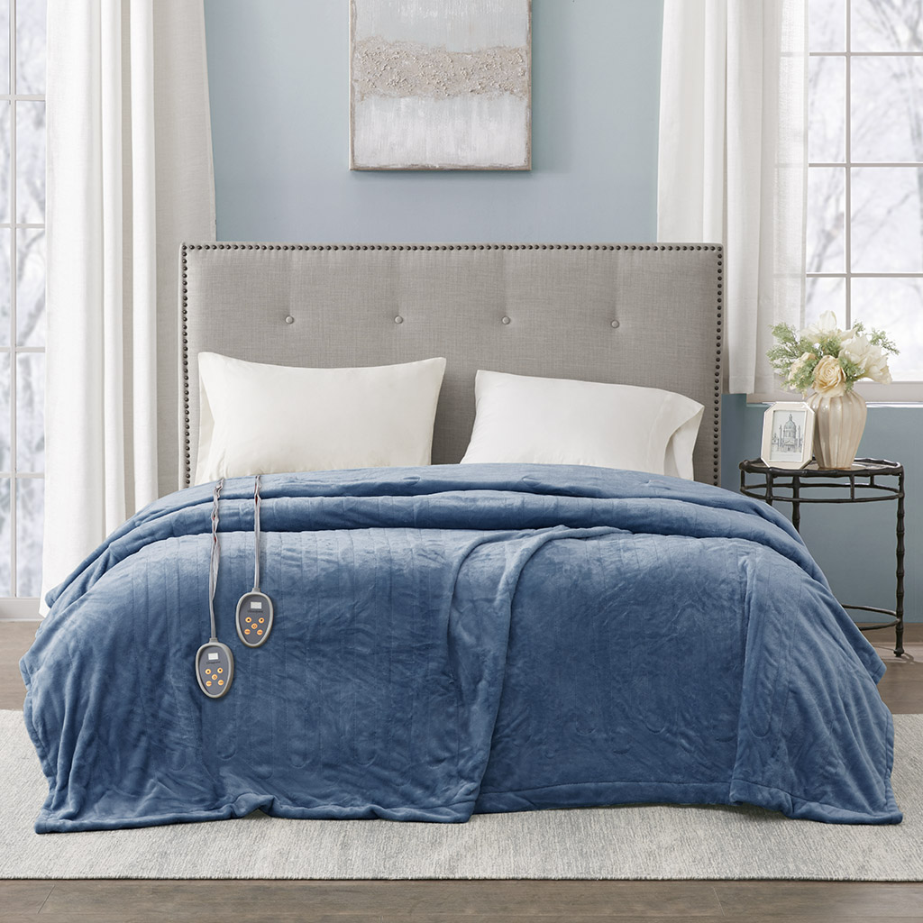 Sapphire-blue Beautyrest heated blanket on a bed, with two wired controllers visible