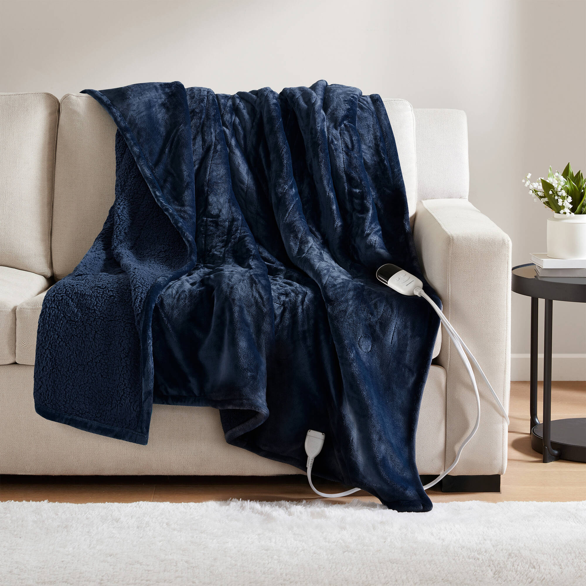 Indigo-looking Beautyrest BR54-0663N heated throw draped over a sofa with a visible wired controller
