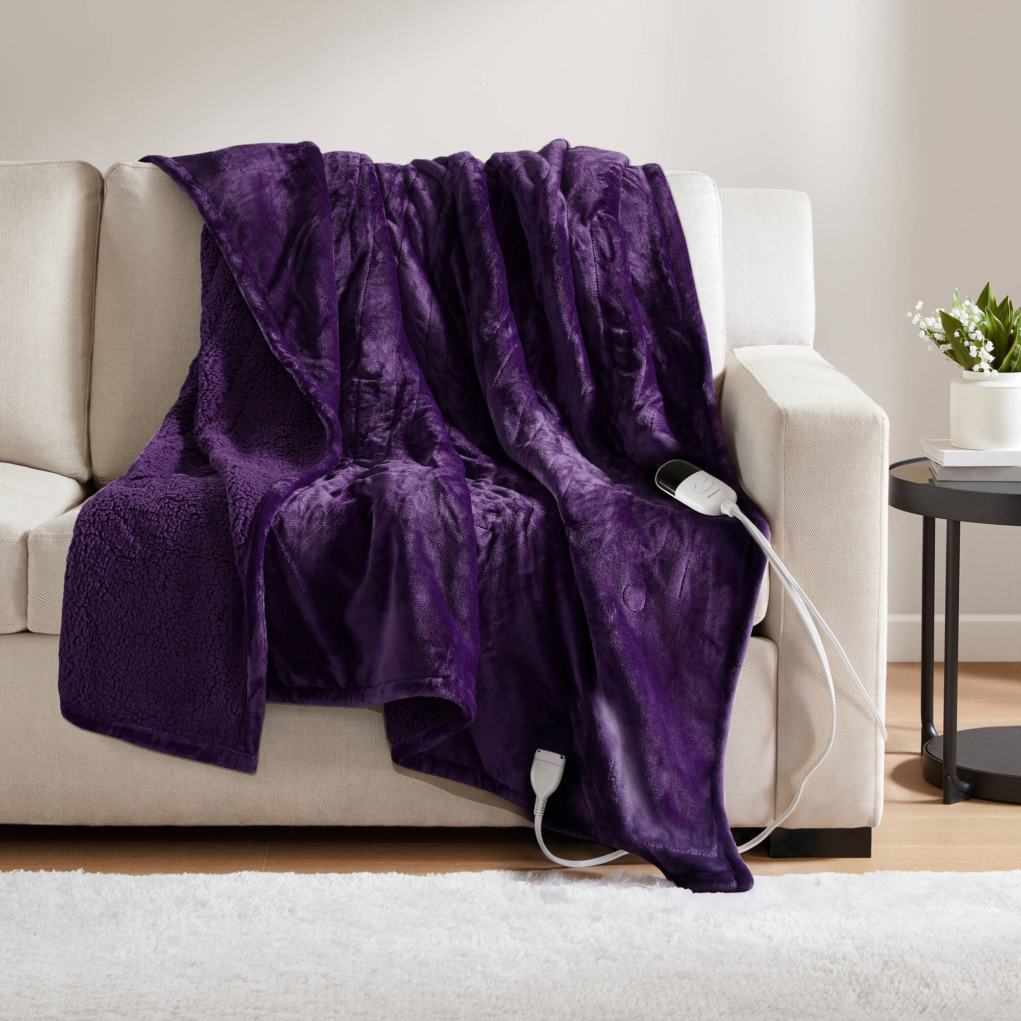 Purple Beautyrest heated throw draped over a sofa; one wired handset and lead are visible in the image.