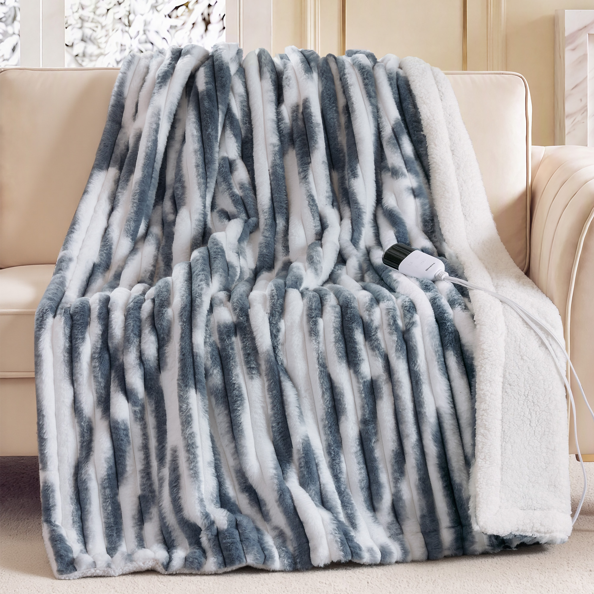 Blue-and-white marbled Beautyrest heated throw draped over a sofa with one wired controller visible