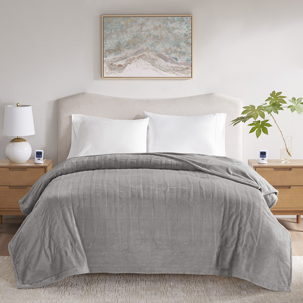 Gray Beautyrest BR54-4128 connected heated blanket staged on a bed with two controllers