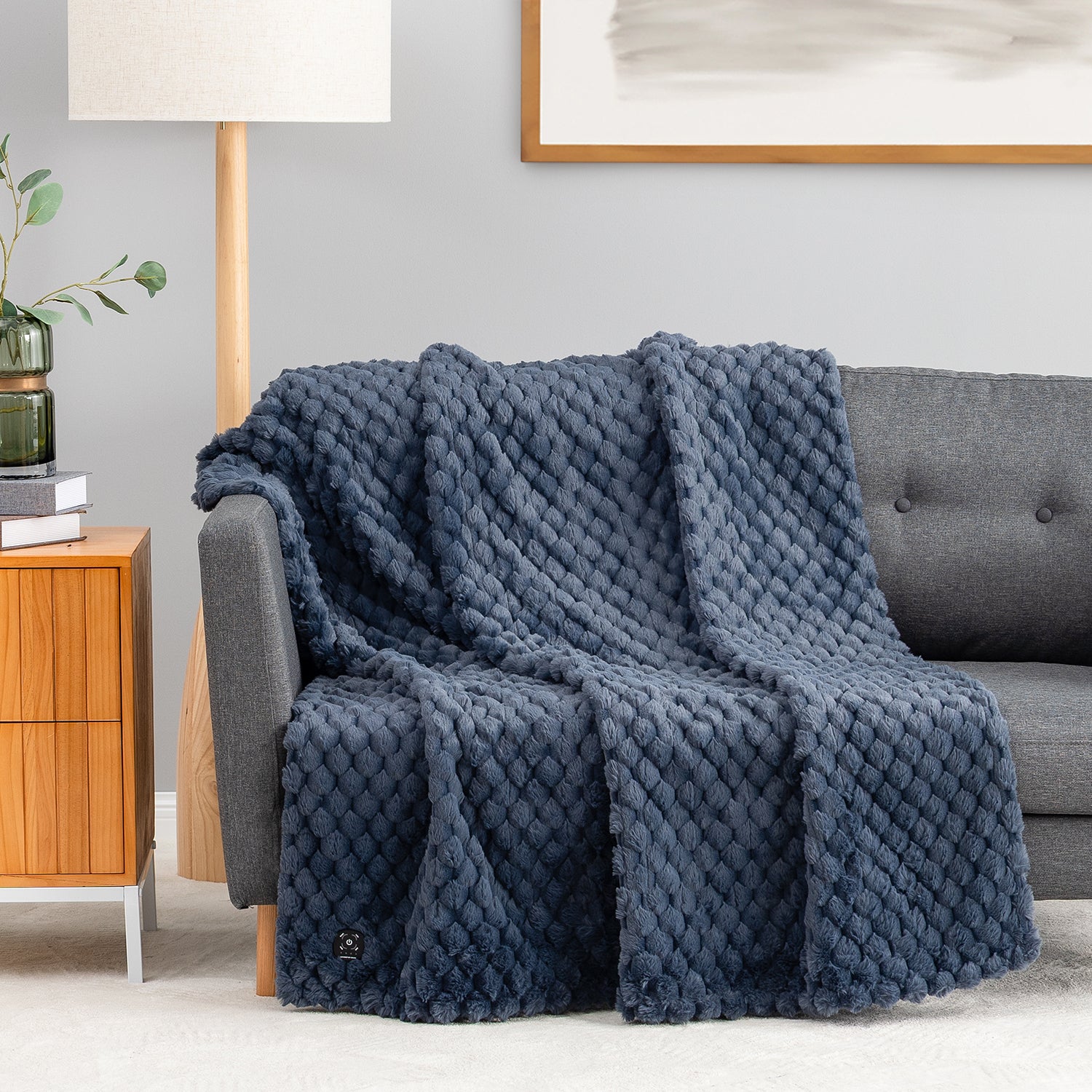 Historical Blue throw Berkshire heated faux-fur throw shown over a sofa