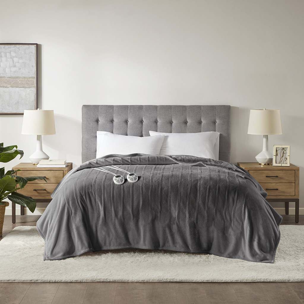 Dark Grey Serta Plush Heated Blanket staged on a bed