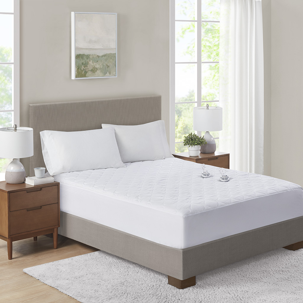 Serta Microfiber heated mattress pad shown on a bed with two small handset controls; exact displayed bed size is not identified.