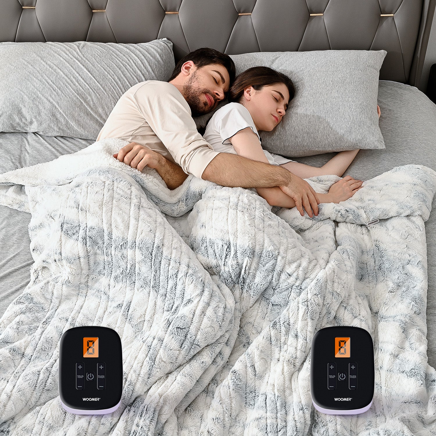 WOOMER Double-sided Marble Blue bed blanket shown on a made bed with two controllers