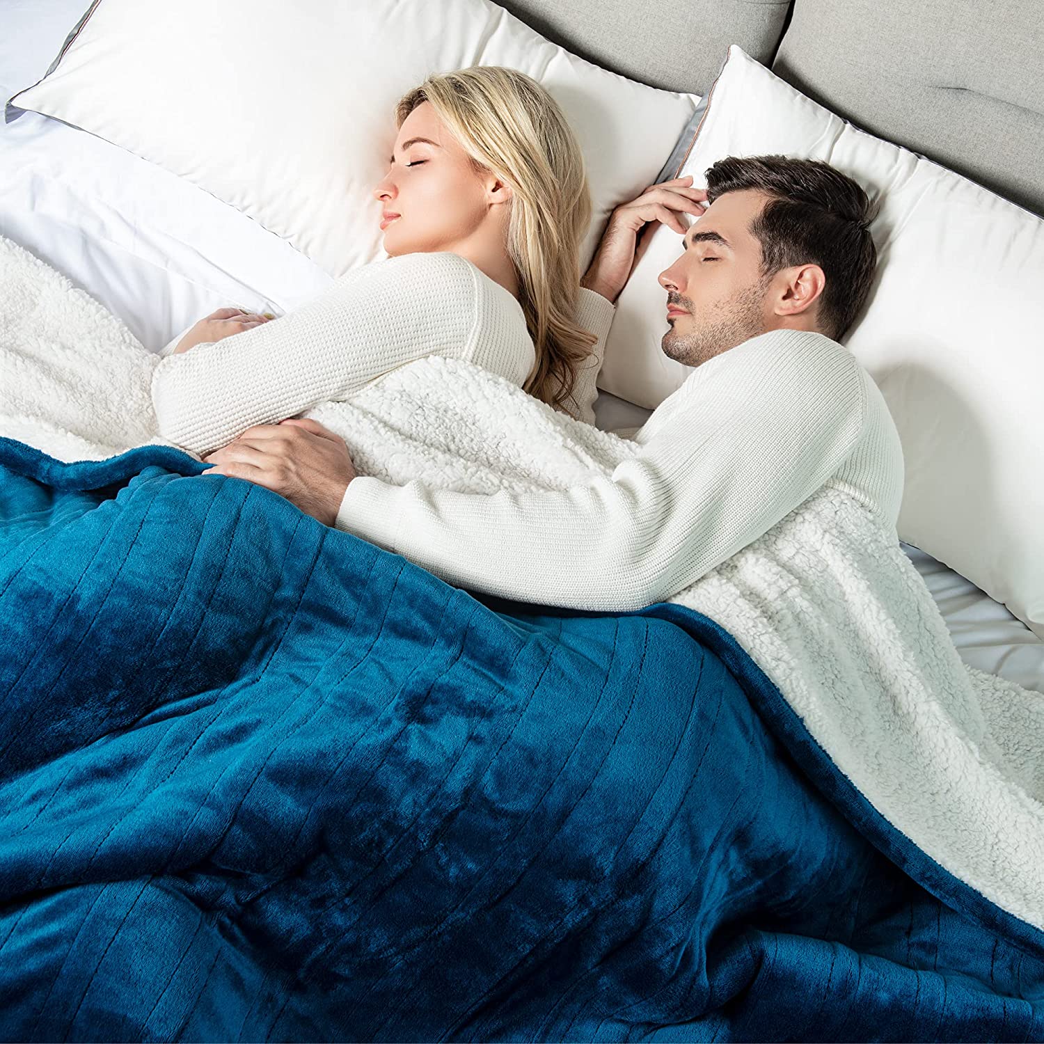 WOOMER store lifestyle image showing a deep blue electric blanket covering two sleepers on a bed